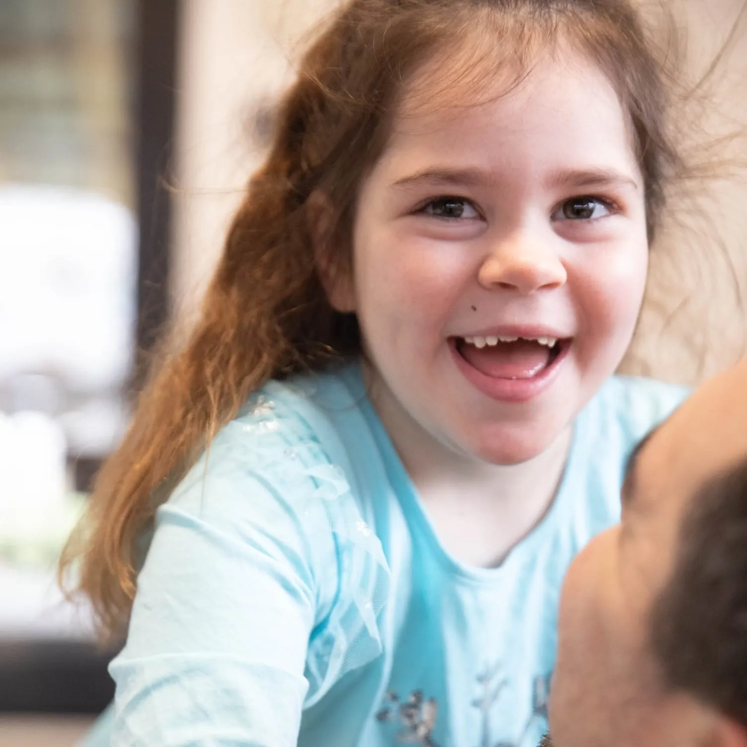 Karolina, a girl with Cockayne syndrome type B, laughing after the fundraising goal was reached